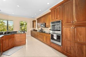 una grande cucina con armadi in legno ed elettrodomestici di Marbury Lane a Sister Keys