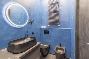 a bathroom with a sink and a toilet and a mirror at La casa di Minù by Houset in Monza