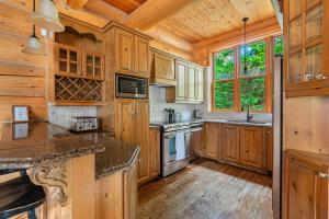 una cucina con mobili in legno e pavimento in legno di Fiddler Lake Resort - Bear 25 a Mille-Isles