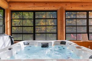 una vasca idromassaggio in una stanza con finestre di Fiddler Lake Resort - Bear 25 a Mille-Isles