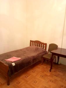 Budget Home في كوتايسي: غرفة نوم بها سرير وطاولة وكرسي