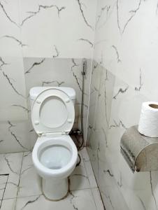 Budget Home في كوتايسي: مرحاض أبيض في حمام بجدران من الرخام