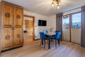 une salle à manger avec une table et des chaises bleues dans l'établissement Apartamenty 61, à Poronin
