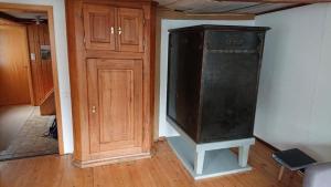 una gran nevera negra en una habitación junto a una puerta en Ferien In Der Vogelherd, en Wolfhalden  15 fotos más