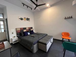 a bedroom with a bed and a table and chairs at Casa Oceanus - Pool Facing Room - Ganpatipule in Nevra +10 photos