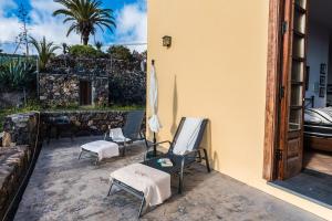 eine Terrasse mit Stühlen, Sonnenschirm und Tisch in der Unterkunft Loft Rural - Caserio De La Hondura in Alajeró + 28 Fotos