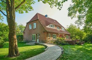 une maison en briques avec un arbre et un chemin dans l'établissement Charming Flat In Historic Country House, à Meezen