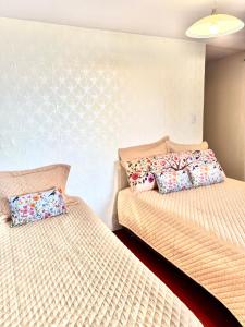 ein Schlafzimmer mit zwei Betten und Kissen darauf in der Unterkunft Cuzco Lodgement in Lima