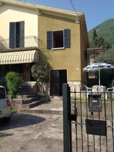 une maison avec une porte et un parasol devant elle dans l'établissement Ferienhaus In Salò Mit Grill, Terrasse Und Garten, à Salò