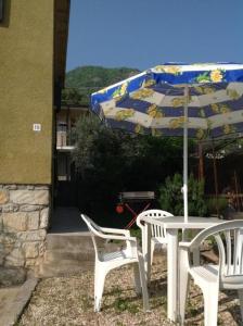 une table, deux chaises et un parasol dans l'établissement Ferienhaus In Salò Mit Grill, Terrasse Und Garten, à Salò