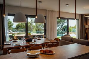 ein Esszimmer mit Tischen und Stühlen und großen Fenstern in der Unterkunft Villa Harmony Brela in Brela