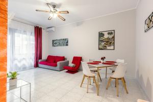 uma sala de estar com uma mesa e um sofá vermelho em Raf Rhome Seaside - Center 200m to the Sea em Lido di Ostia