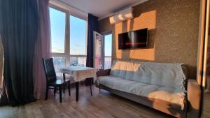 un salon avec un canapé et une table dans l'établissement Panoramic view Lebedinny flat, à Kiev
