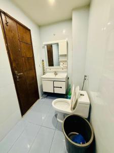 een witte badkamer met een toilet en een wastafel bij One Bed Luxury Flat Apartment Bahria Town Islamabad in Rawalpindi