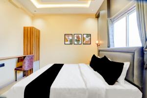 a bedroom with a bed and a desk and a window at Hotel O Fortune Palace in Hinjewadi