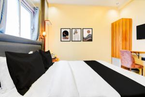 a bedroom with a black and white bed with pictures on the wall at Hotel O Fortune Palace in Hinjewadi +22 photos