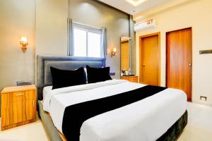 a bedroom with a large bed and a window at Hotel O Fortune Palace in Hinjewadi