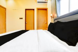 a bed in a room with two doors at Hotel O Fortune Palace in Hinjewadi