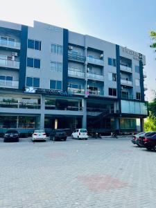 een groot gebouw met auto's geparkeerd op een parkeerplaats bij One Bed Luxury Flat Apartment Bahria Town Islamabad in Rawalpindi