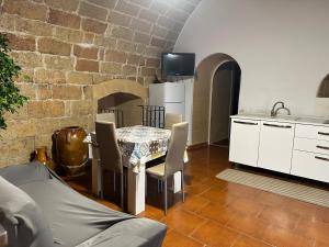 a kitchen with a table and white cabinets and a brick wall at casa Carlos in Bari Palese