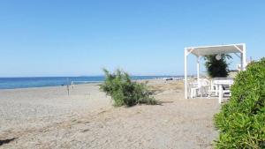 a beach with a gazebo and chairs on the beach at Wunderschönes Ferienhaus In Marchesana in Terme Vigliatore