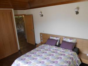 a bedroom with a bed with purple pillows at Casa do Alto in Magrelos