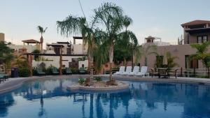 ein Swimmingpool mit Stühlen und einer Palme in der Unterkunft Welcome to Casa Sonrisas, charming and peaceful in Nopoló