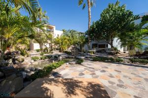 einen Innenhof mit Palmen und ein Haus in der Unterkunft Welcome to Casa Sonrisas, charming and peaceful in Nopoló