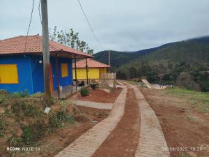 een blauw en geel huis naast een onverharde weg bij Chalé Emília Costa in Ouro Preto