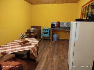 een keuken met een koelkast en een tafel in een kamer bij Chalé Emília Costa in Ouro Preto