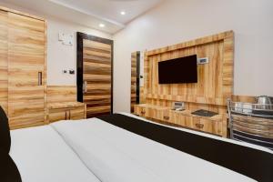 a bedroom with a bed and a flat screen tv at Townhouse Oak CSJMU Kanpur Formerly Shree Dev Villa in Kaliānpur