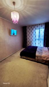 une chambre avec un lit et un lustre dans l'établissement Ferval Confort Craiova, à Craiova