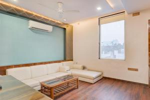 a living room with a couch and a table at Townhouse Oak CSJMU Kanpur Formerly Shree Dev Villa in Kaliānpur