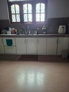 Una cocina con gabinetes blancos y un fregadero. en ADLi, en Pambahinna