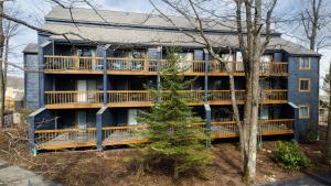 a blue building with balconies and a tree at Timbers Studio 14 with Wintergreen Advantage in Wintergreen