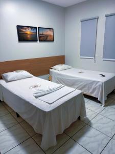 deux lits dans une chambre avec des draps blancs dans l'établissement Hotel dos Reis, à Belém