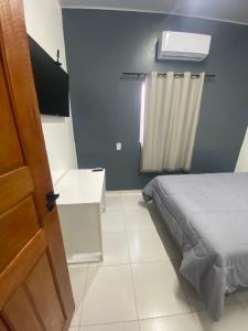 ein kleines Schlafzimmer mit einem Bett und einem Fenster in der Unterkunft AeroBelém - Apart & Residence in Belém