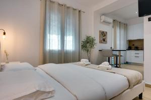 Il comprend une chambre blanche avec deux lits et une cuisine. dans l'établissement CityLife studio 2'from metaxourgio station 2A, à Mesochórion