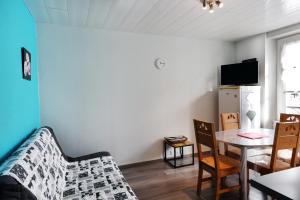 a living room with a table and a couch at Appartement Rue du lac in Gérardmer