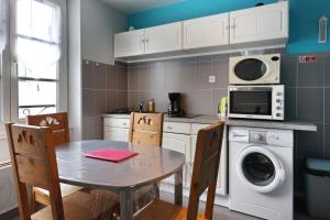 a kitchen with a table and a microwave at Appartement Rue du lac in Gérardmer