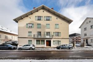 a building with cars parked in a parking lot at Appartement Rue du lac in Gérardmer