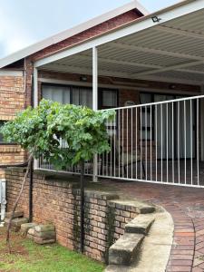 a porch with a white railing on a house at Hillsview, Roodepoort in Roodepoort