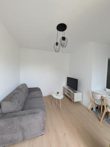 un salon avec un canapé et une table dans l'établissement Maison Le cottage, à Crosne