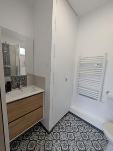 une salle de bains avec lavabo, toilettes et miroir dans l'établissement Maison Le cottage, à Crosne
