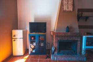 een woonkamer met televisie en open haard bij La Llave Rural in Benaocaz +1 foto