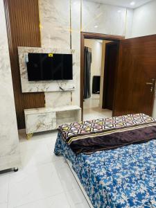 una camera da letto con un letto e una TV a schermo piatto di Peaceful Stay 2nd Home Appartment a Faisalabad