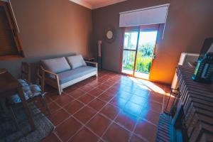 een woonkamer met een bank en een raam bij La Llave Rural in Benaocaz