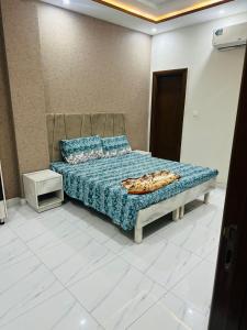 una camera da letto con un letto con un piumone blu di Peaceful Stay 2nd Home Appartment a Faisalabad