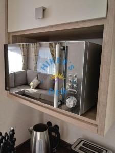 a microwave oven with a couch inside of it at Hikers Den, Brigham, Cockermouth, Cumbria in Cockermouth