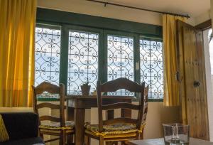 a dining room with a table and chairs and windows at Casa El Limonero, Landhaus Mit Aussicht in Dúrcal